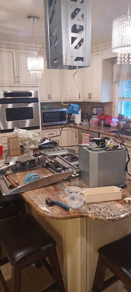 Range hood removal mid-repair in a home kitchen